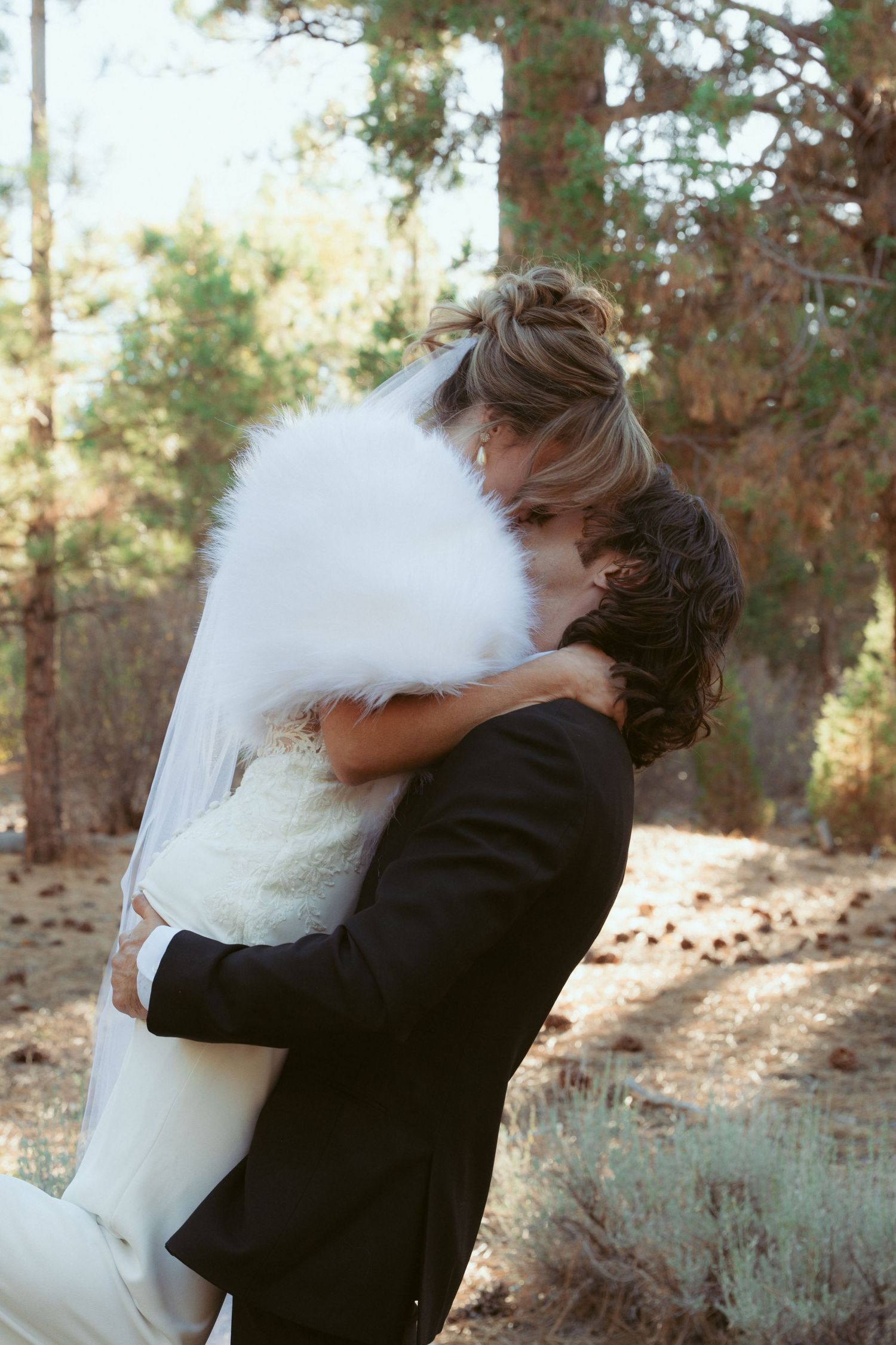A tender embrace captured during a forest wedding photoshoot with natural lighting.