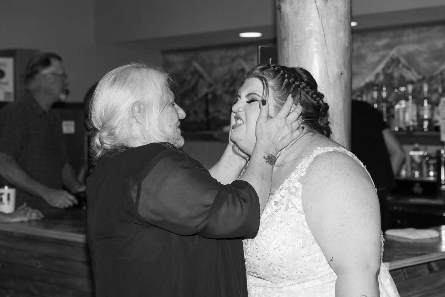 Black and white photo of guests dancing and mingling at a wedding reception venue.