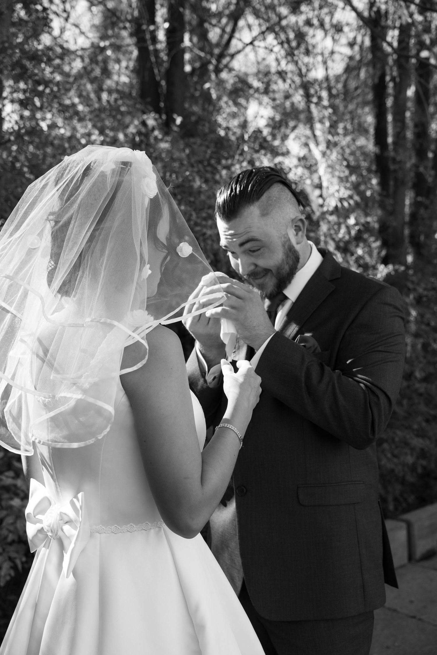 Emotional wedding moment captured in black and white with couple wiping tears.
