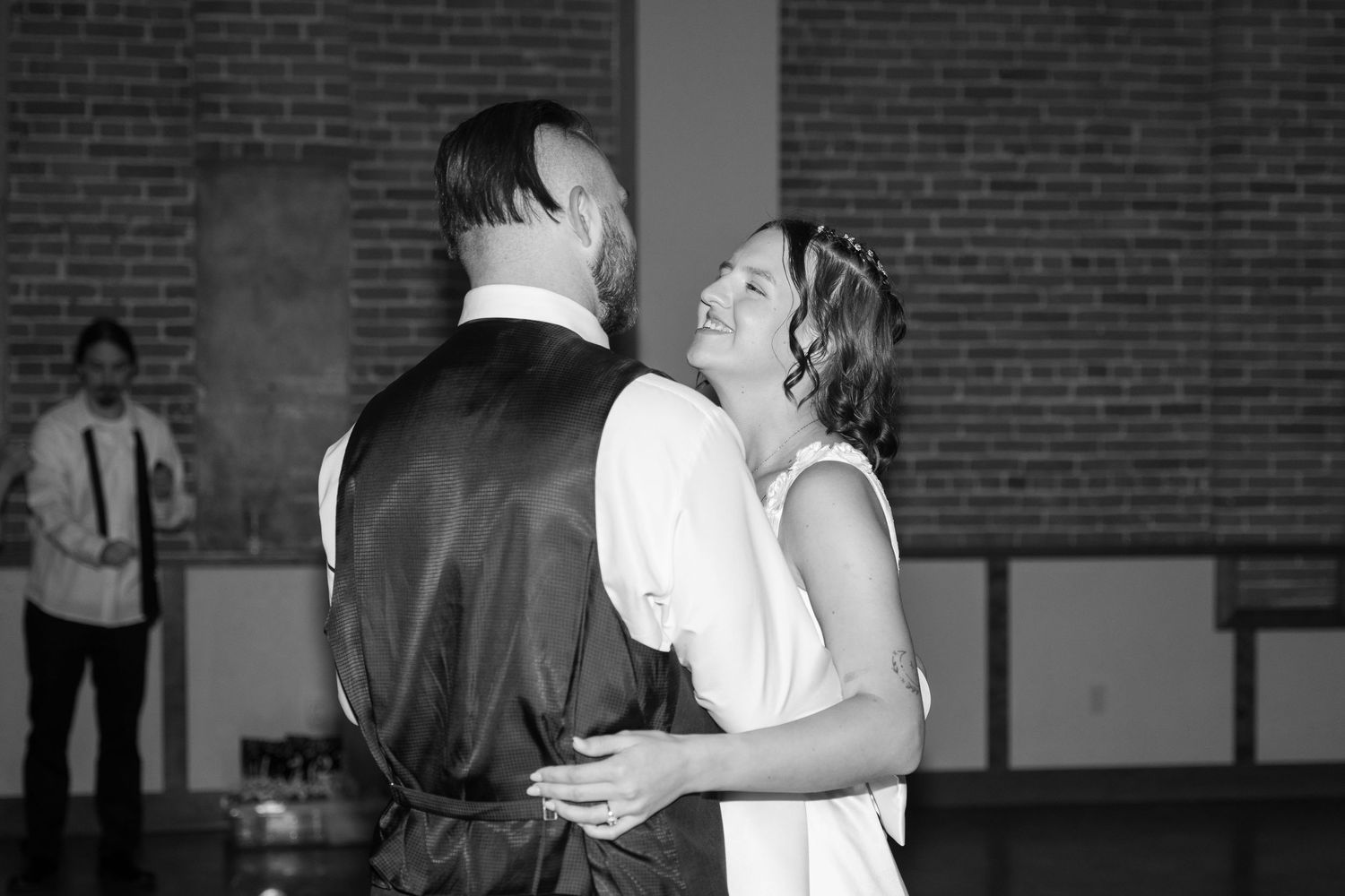 Black and white photo of couples dancing at a wedding reception in a historic venue.