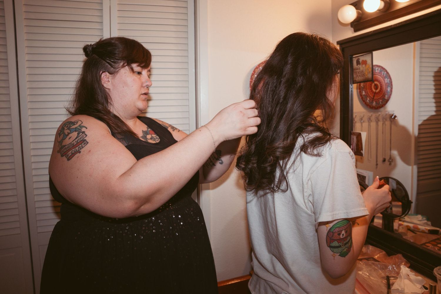 People gathered in a dimly lit room with vanity lights preparing for a special occasion.