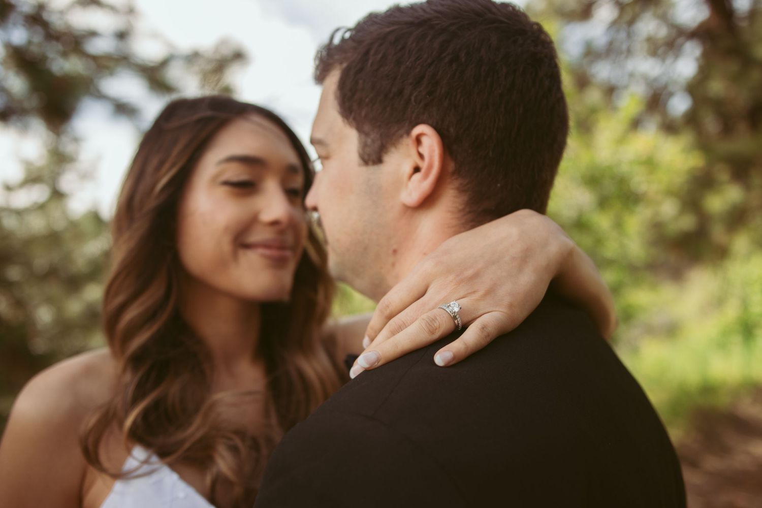 An intimate moment between newlyweds on a sunny forest path.