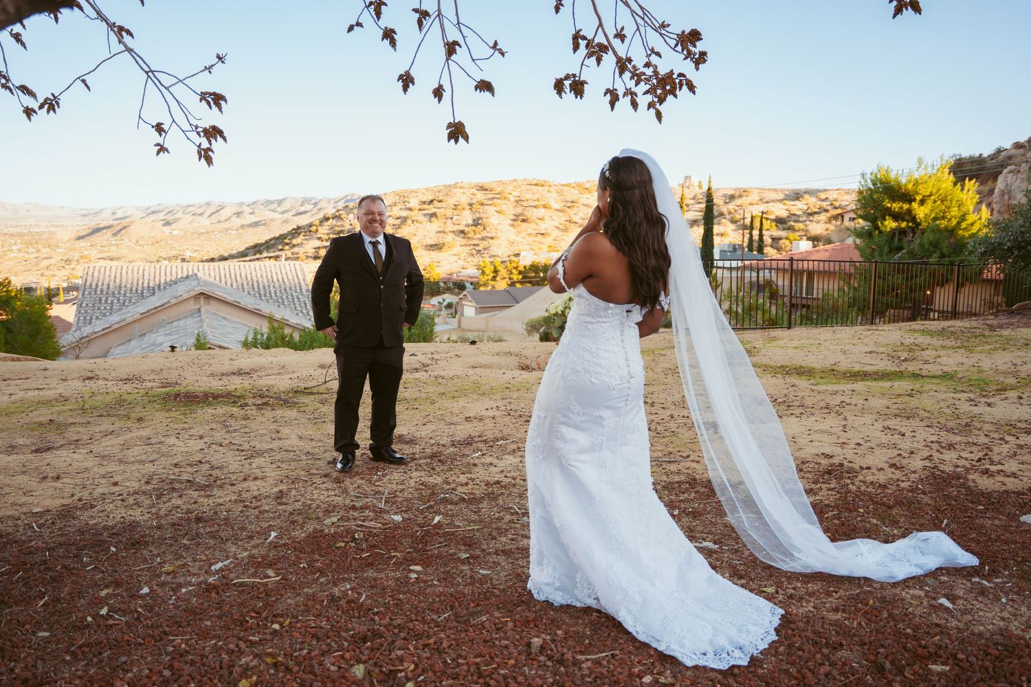 Wedding ceremony procession in desert setting with mountain backdrop at sunset.
