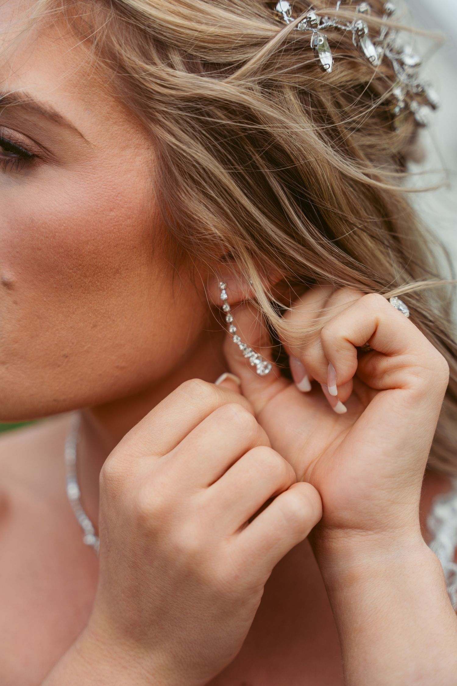 Close-up shot of someone putting on delicate crystal jewelry.