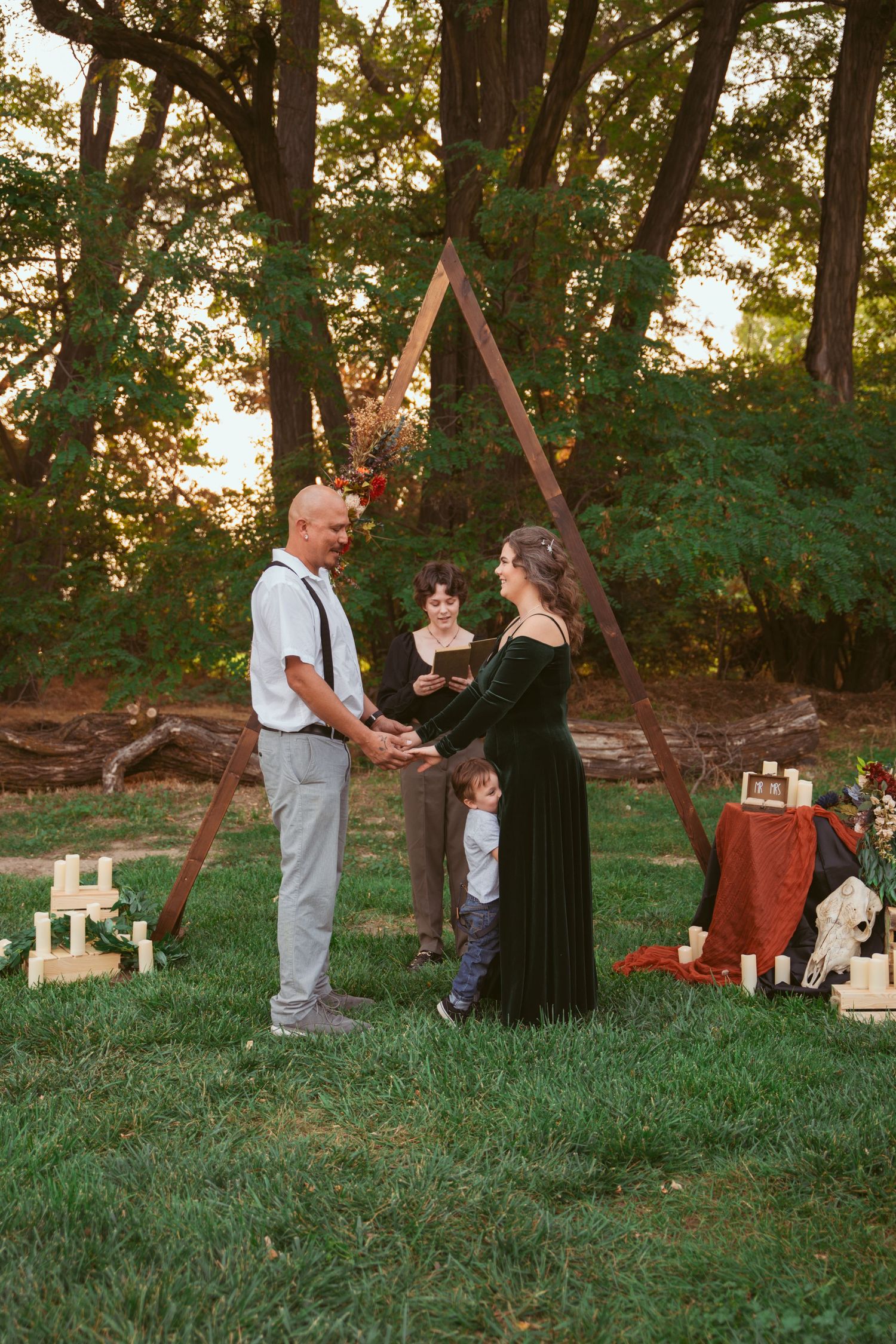 People interact in a park setting with folding chairs and trees during golden hour.
