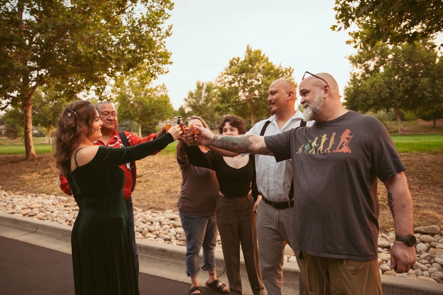 Friends laughing and celebrating together outdoors during sunset.