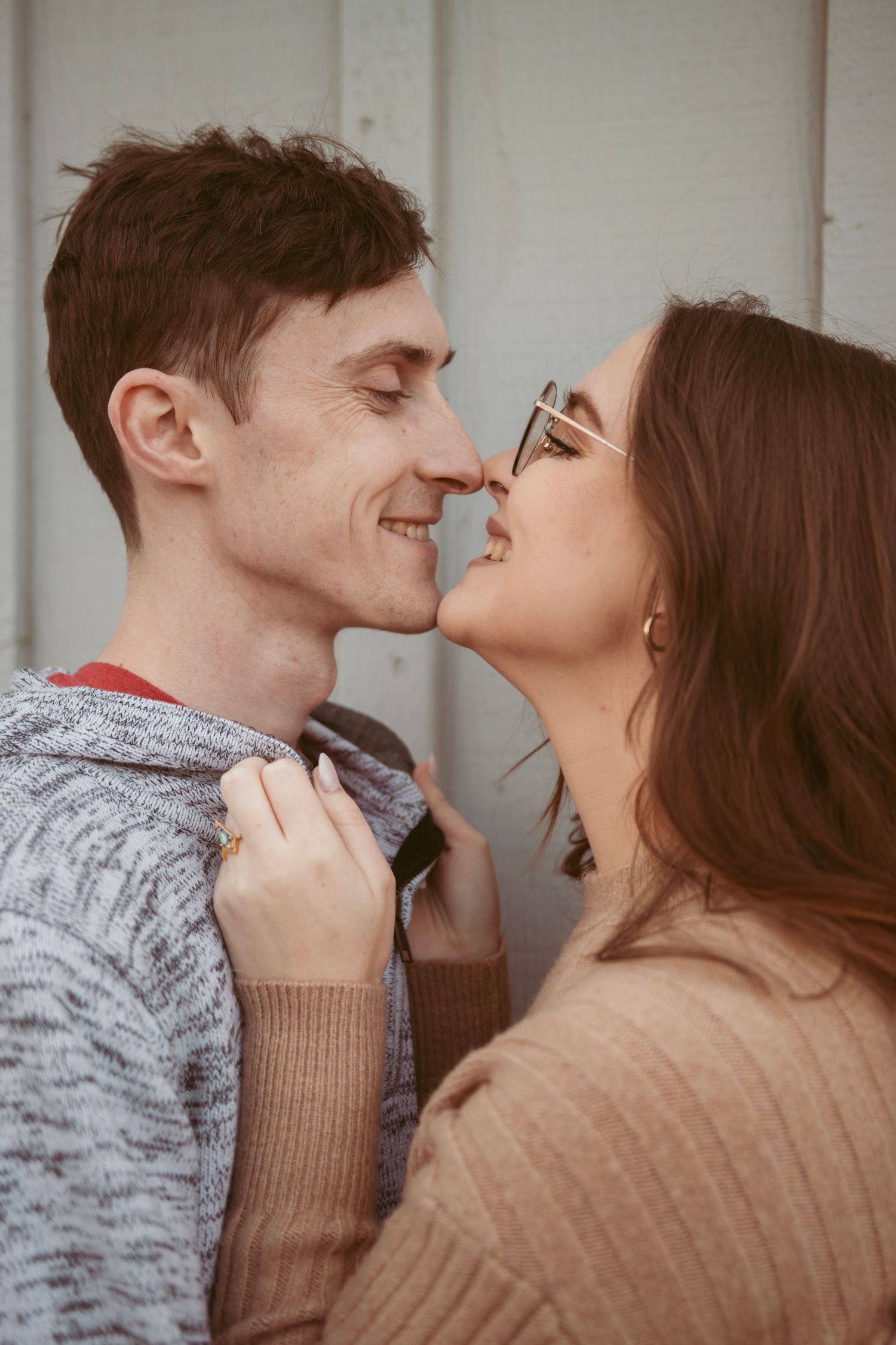 An intimate moment between a couple in warm sweaters as they lean in close together.