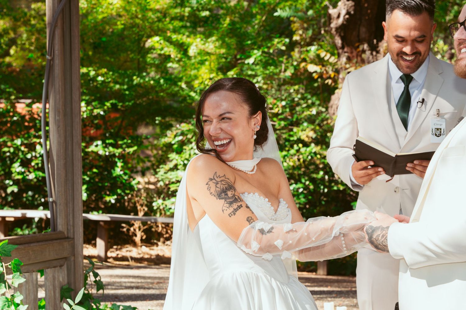 Wedding celebration in a lush garden setting with guests dancing and laughing together.