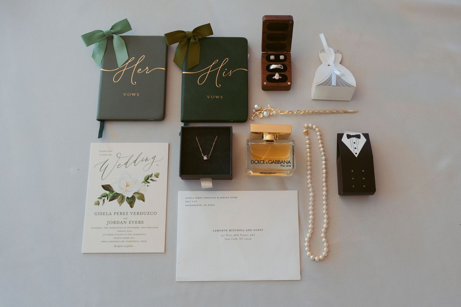 Wedding accessories and jewelry displayed with invitation cards and decorative boxes.