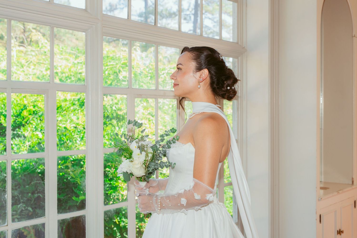 Light-filled room with white curtains and elegant bridal preparations.