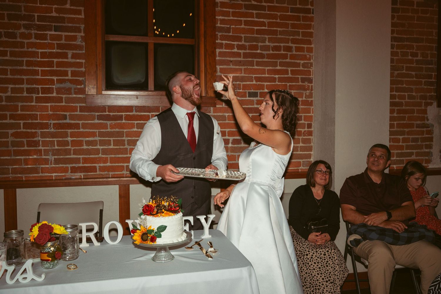 Wedding celebration showing cake cutting and dancing moments in a rustic venue.