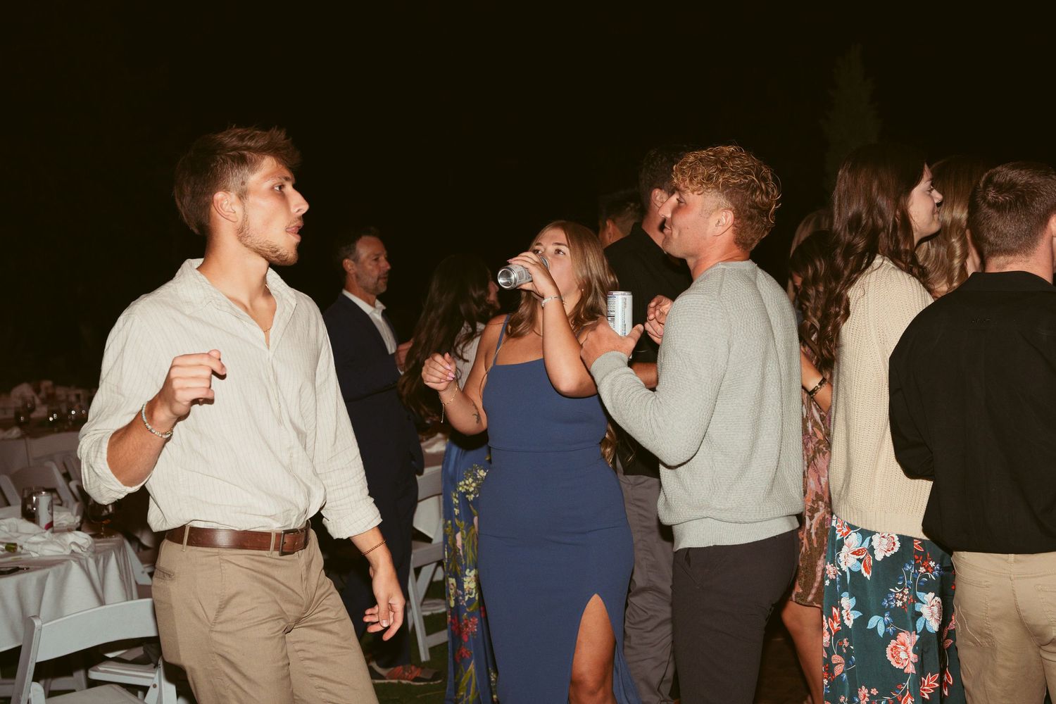 Guests enjoying themselves on a dimly lit dance floor at an evening celebration.