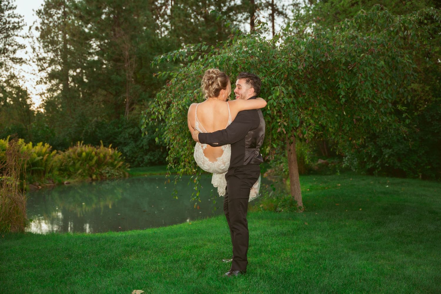 Couple shares an intimate moment in a garden setting at sunset.