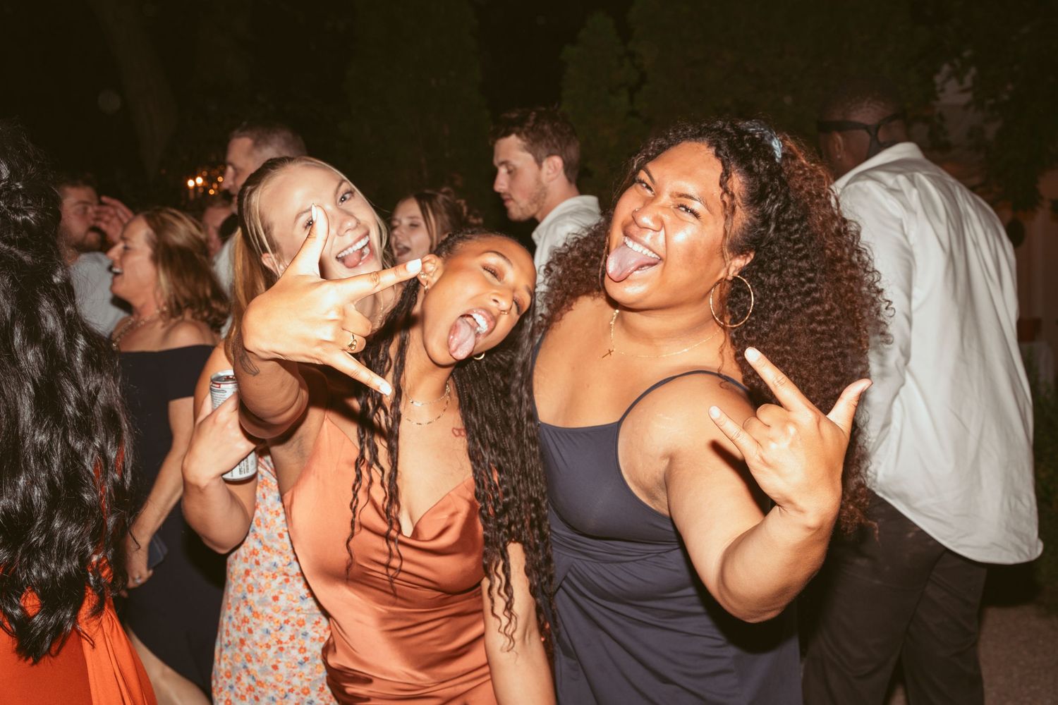 Joyful party guests dancing and having fun at a nighttime celebration.