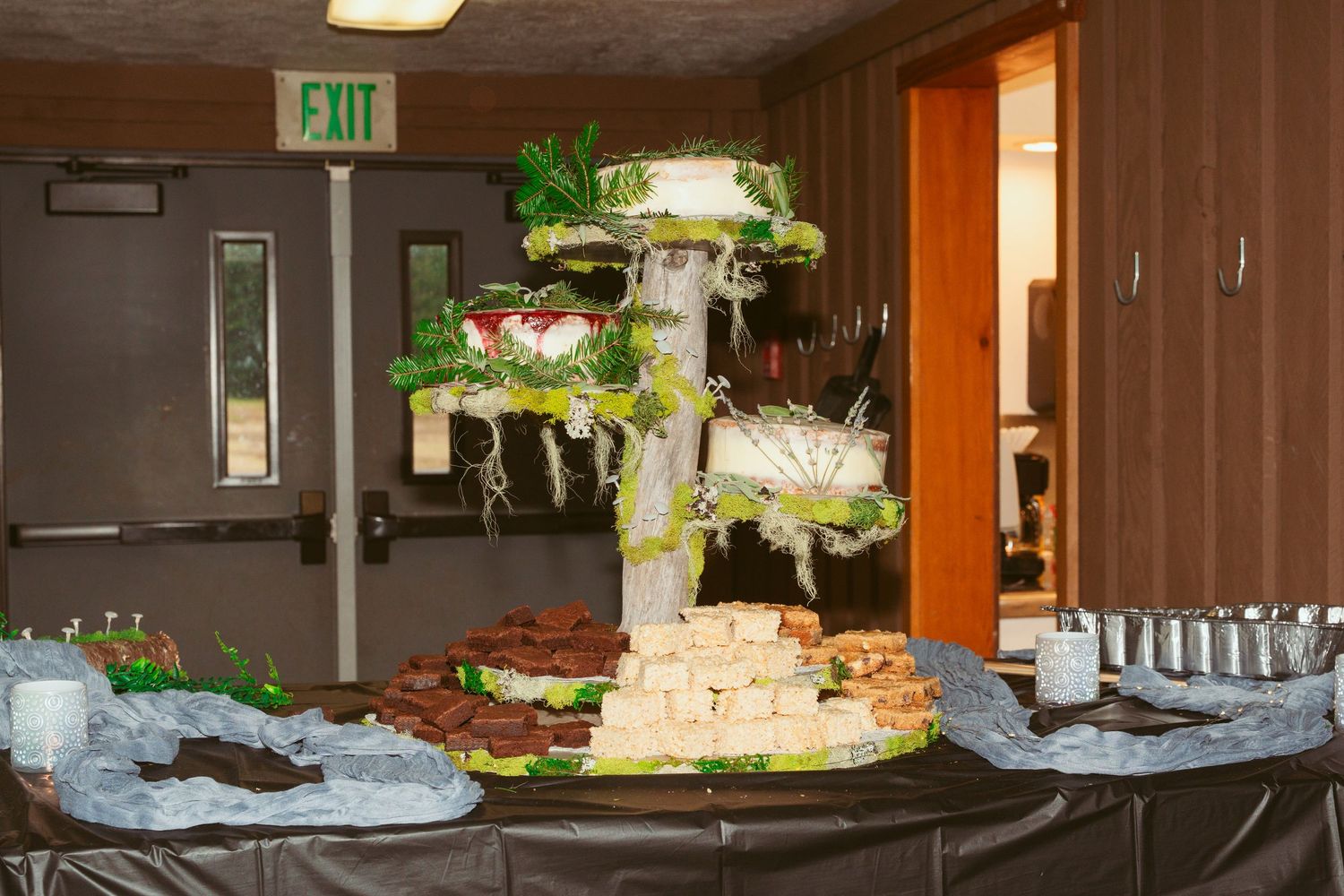Elegant food display table with multiple levels in a dimly lit venue.