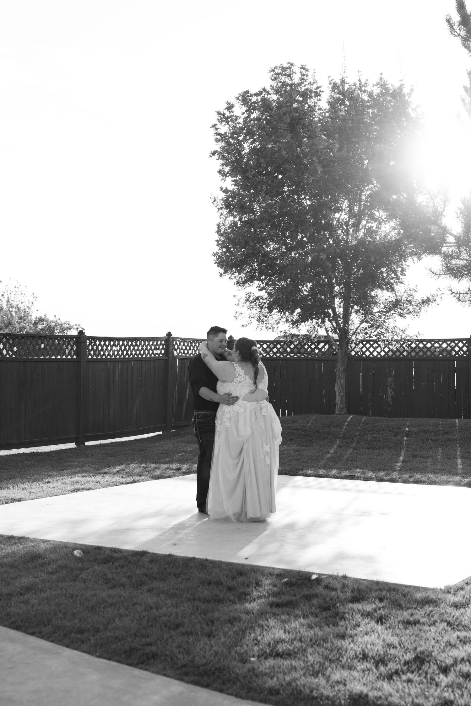 Black and white photo of dancing couples on an outdoor patio with lattice fencing.