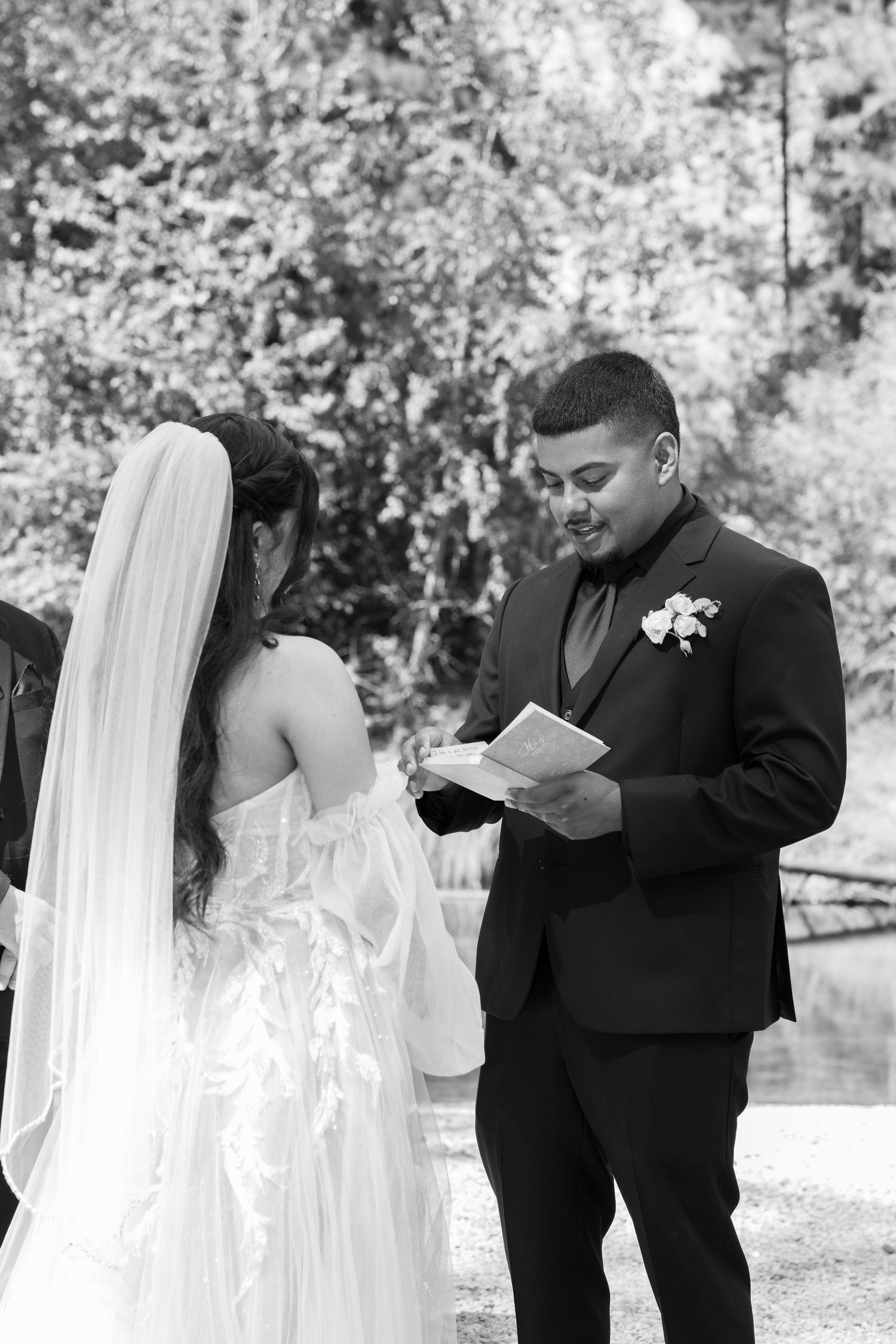 Couple sharing emotional moment during wedding vow exchange in black and white.