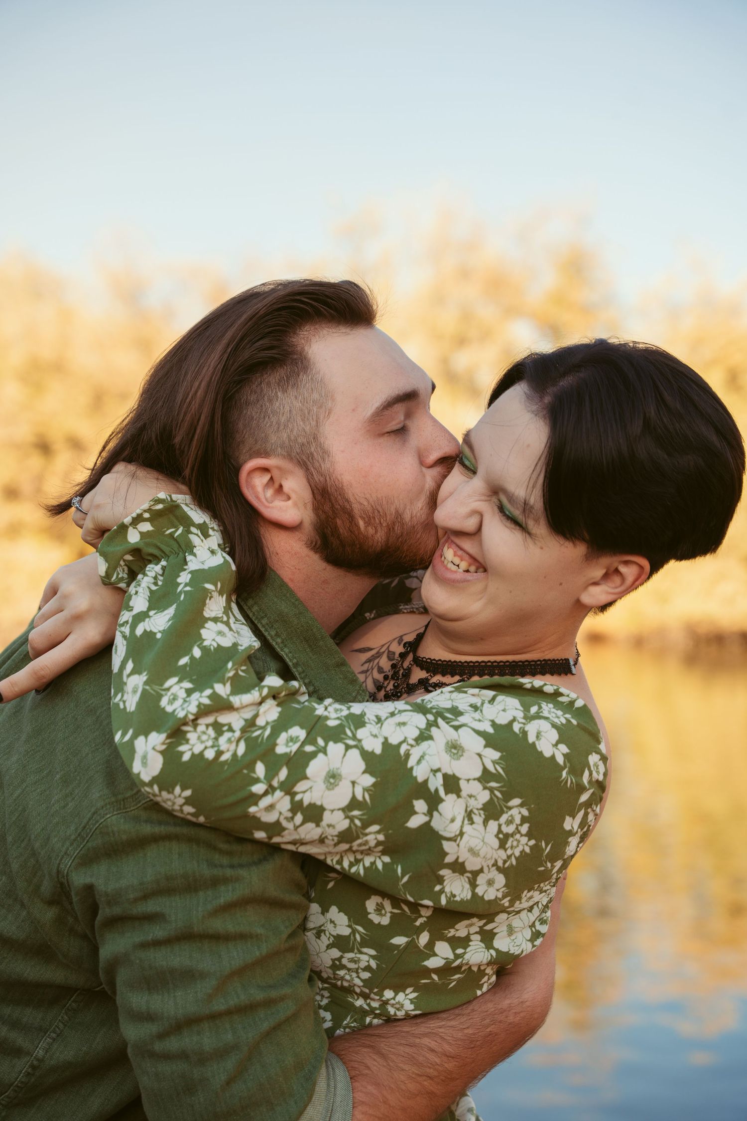 A joyful embrace captured by the water during golden hour.