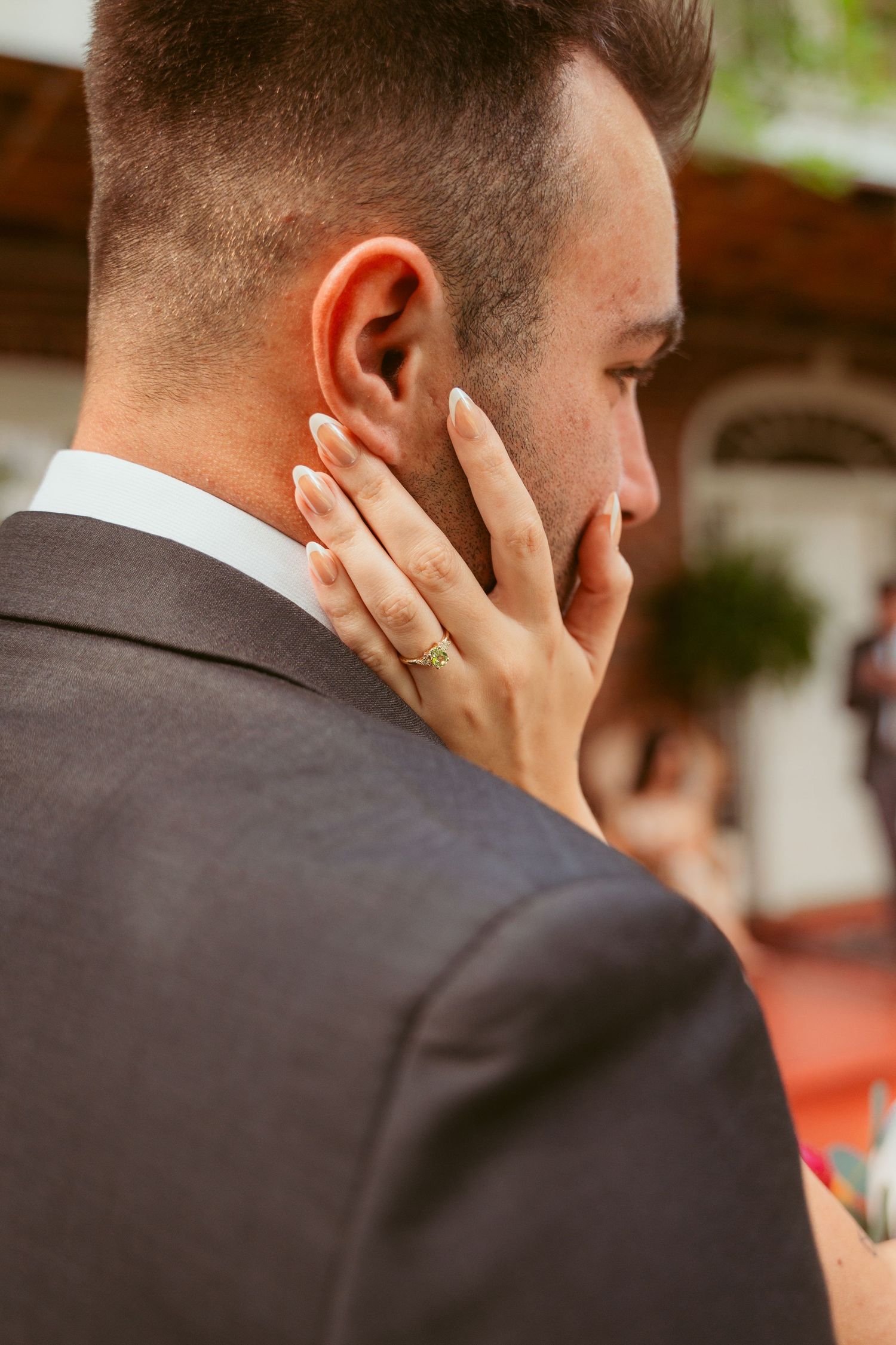 Close-up detail shot of wedding ring and gentle touch during intimate moment.
