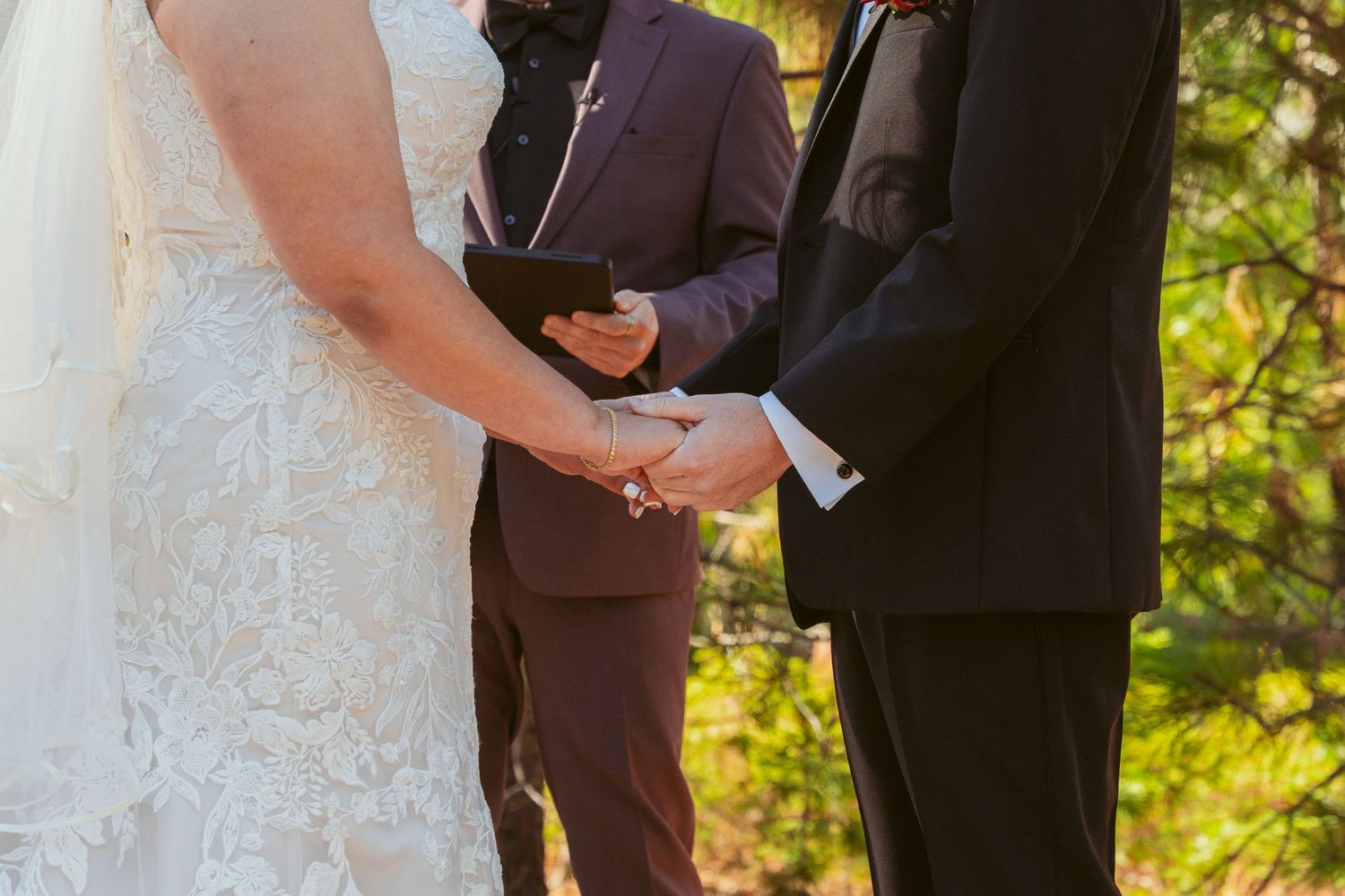 Couple exchanging vows during outdoor forest wedding ceremony.