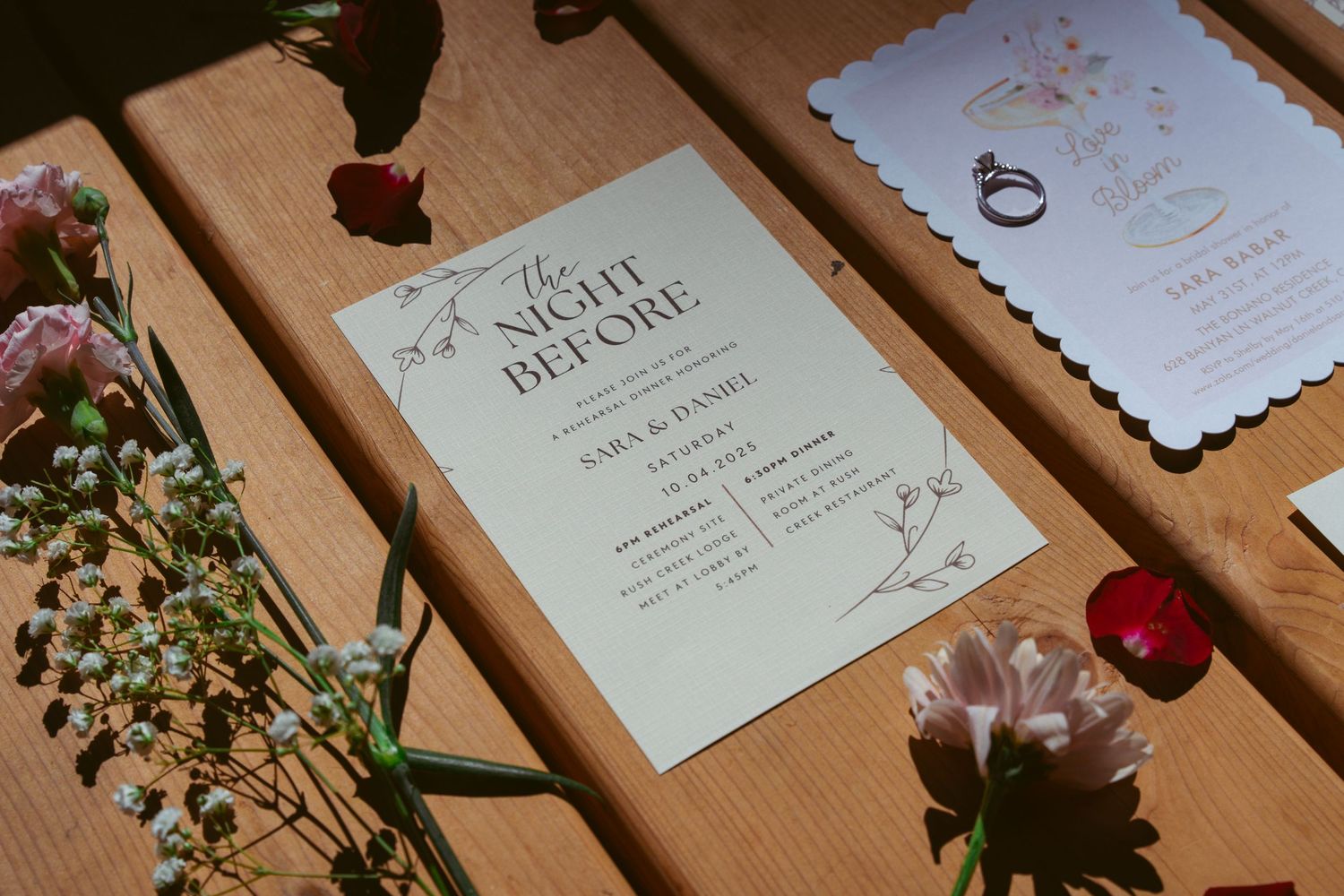 Wedding invitation suite with floral details spread across wooden table.