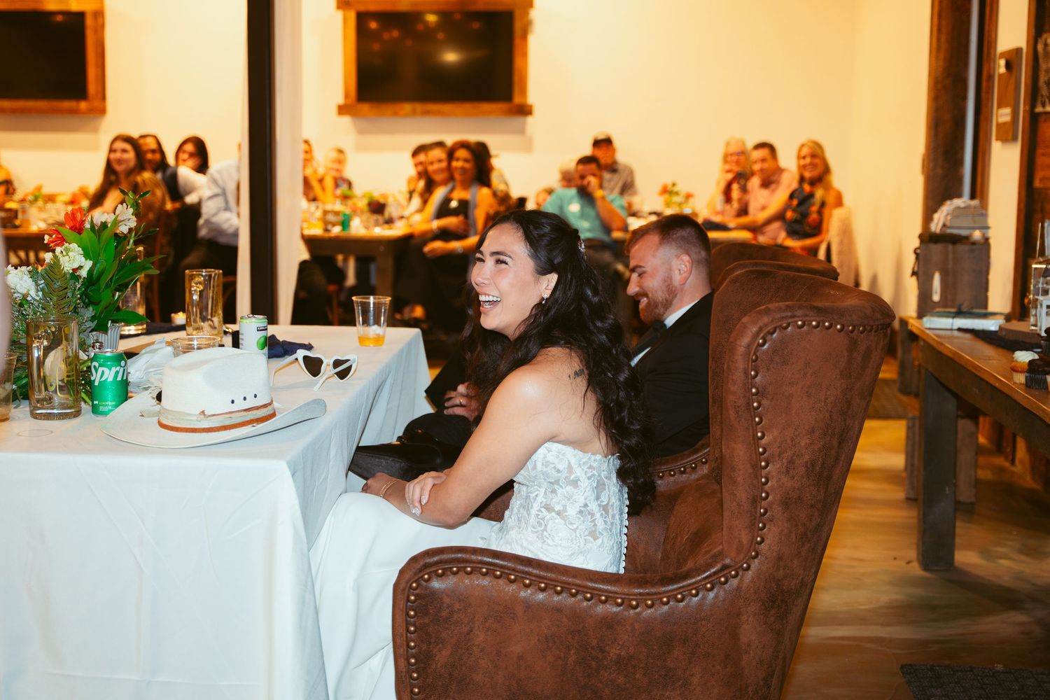 Reception hall setup with elegant table settings and warm ambient lighting for evening celebration.