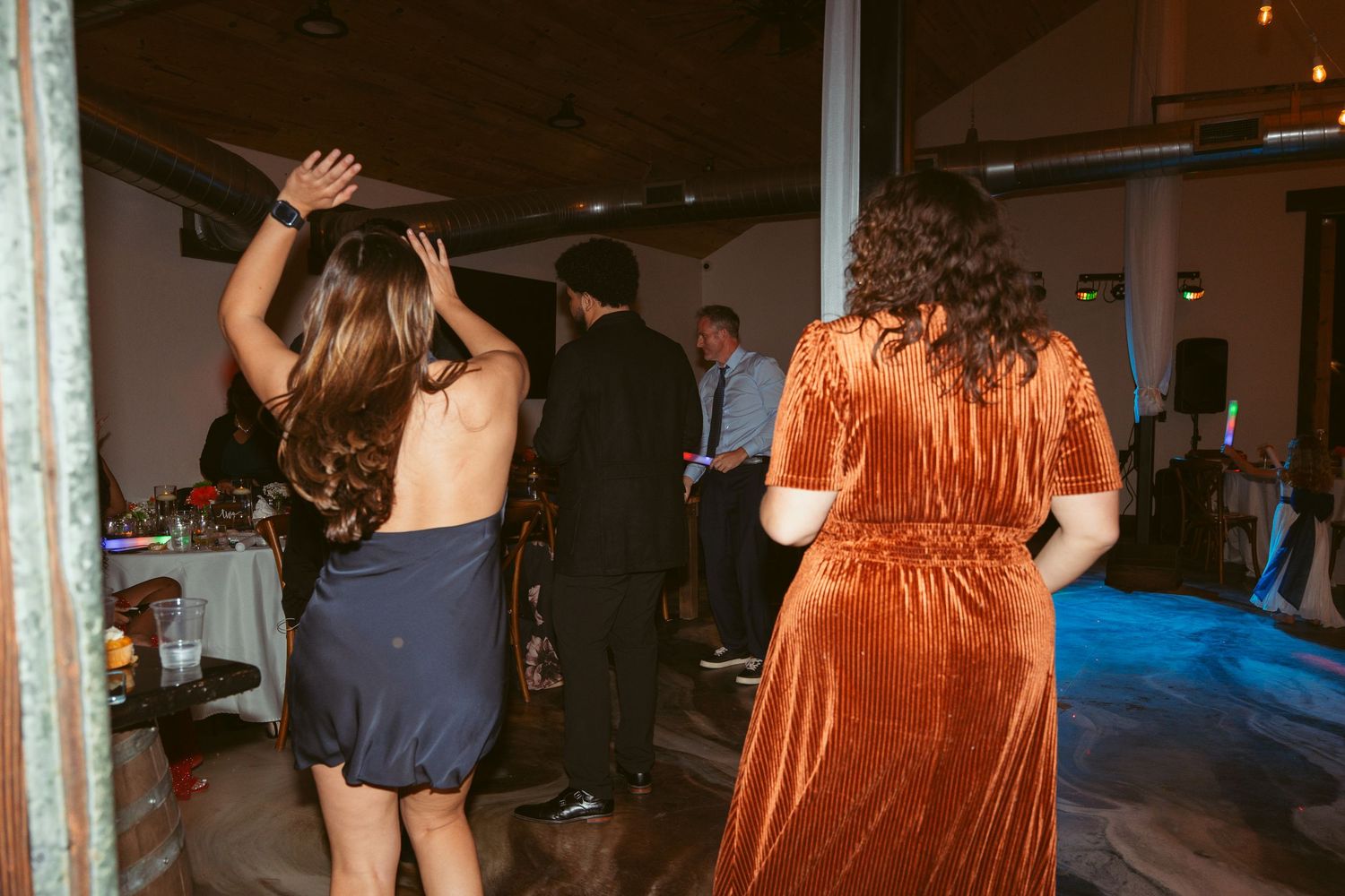 Party guests dancing and moving on the dance floor during an evening celebration.