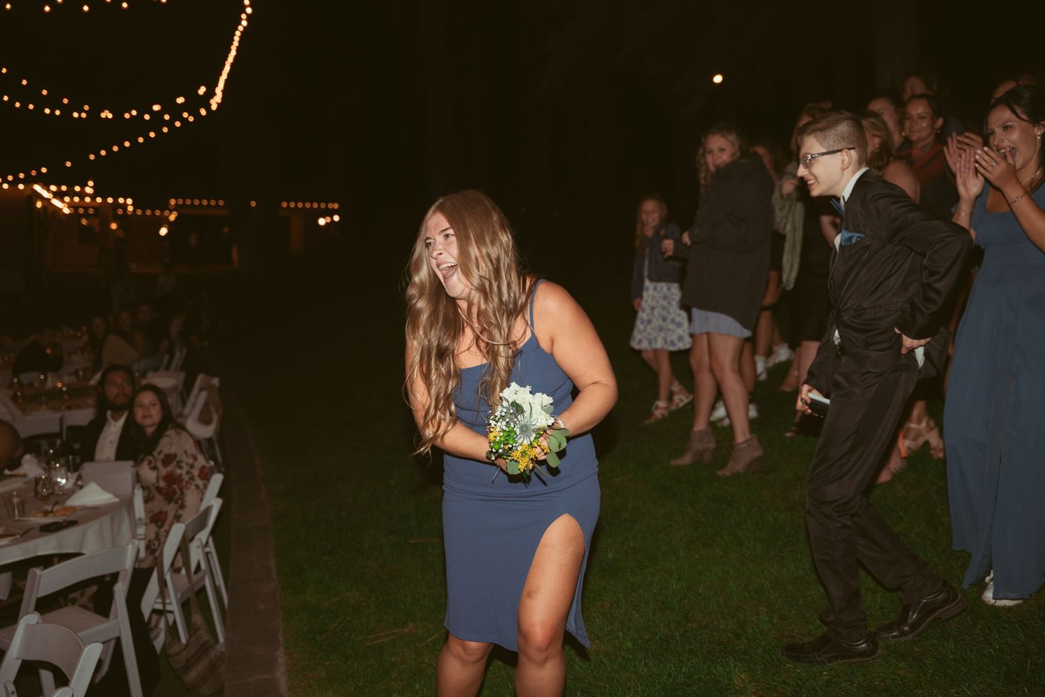 Guests enjoying themselves on a dance floor at an evening outdoor wedding reception.