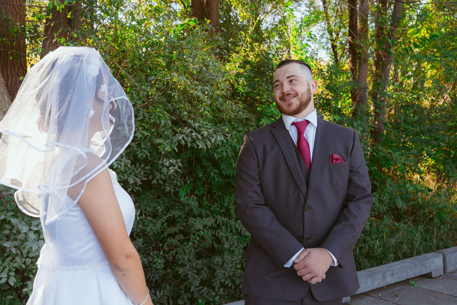 Wedding couple's first look moment captured in natural outdoor lighting.