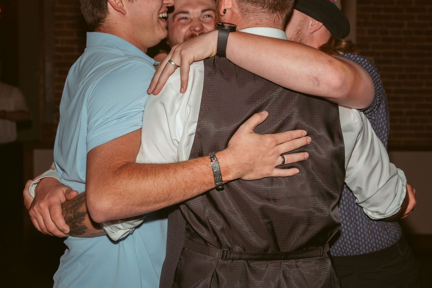 Group of people embracing during an emotional moment at a celebration.