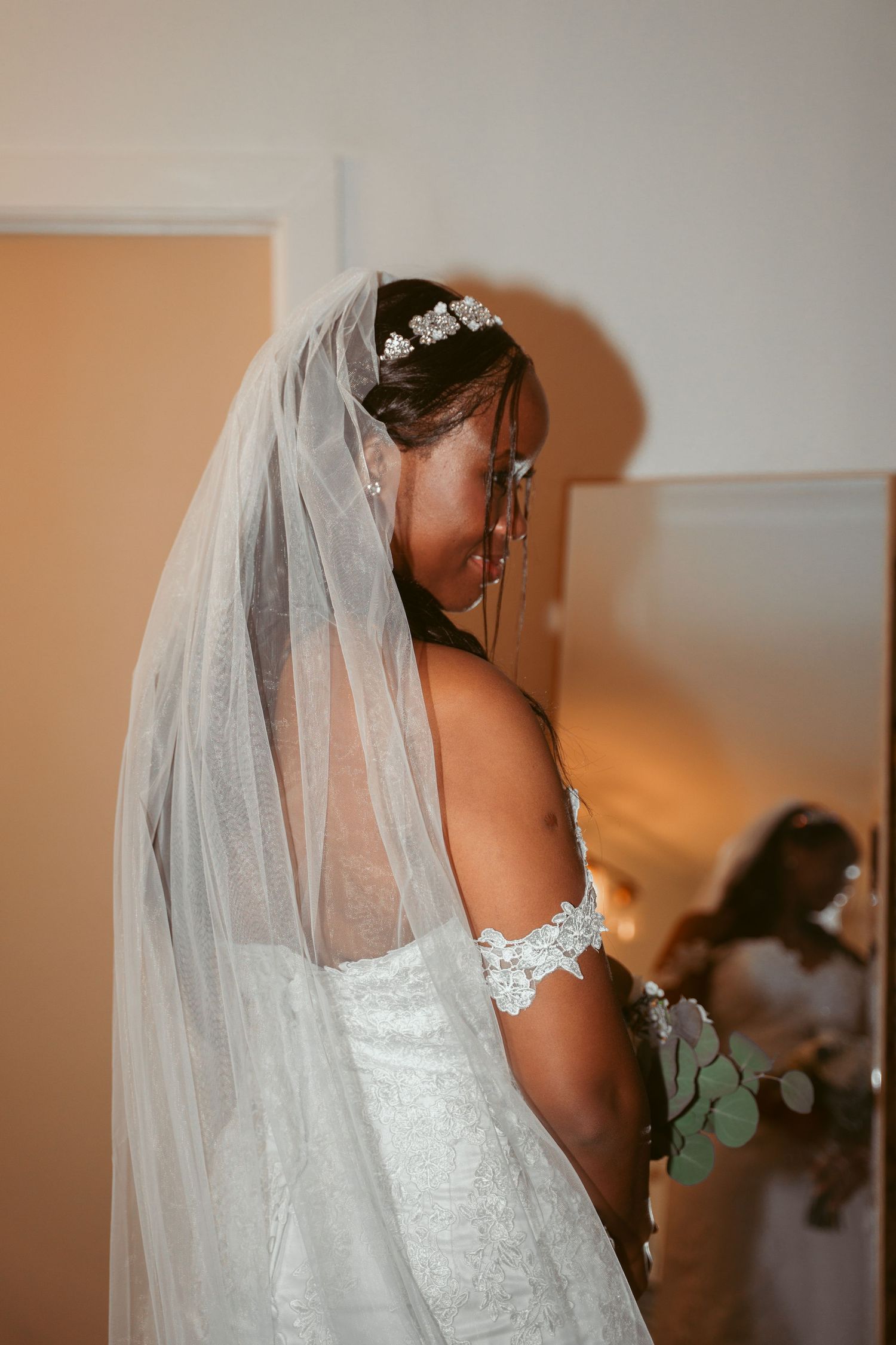 Close-up details of an elegant white lace wedding dress with veil.