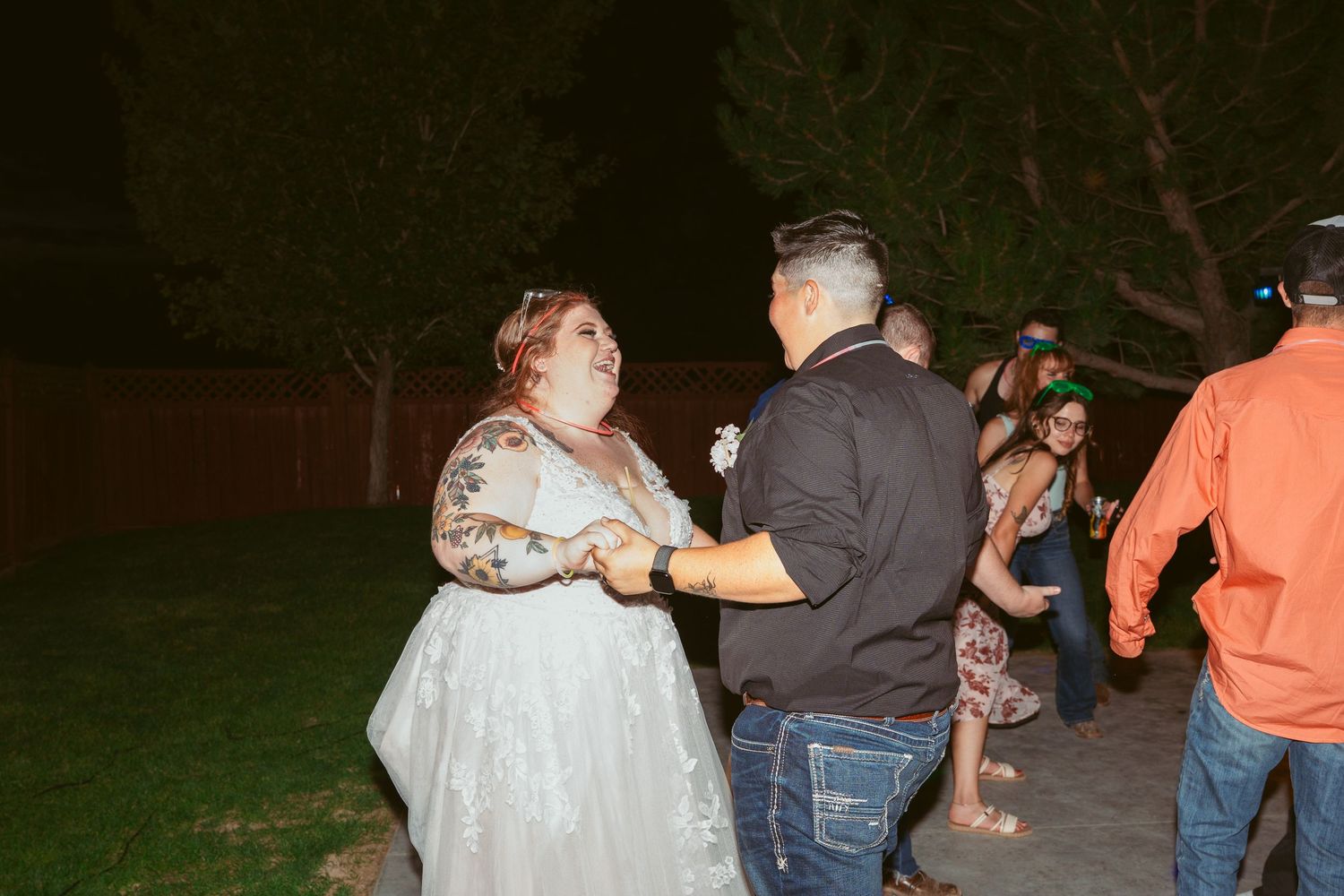 Couple dancing together at outdoor evening wedding reception.