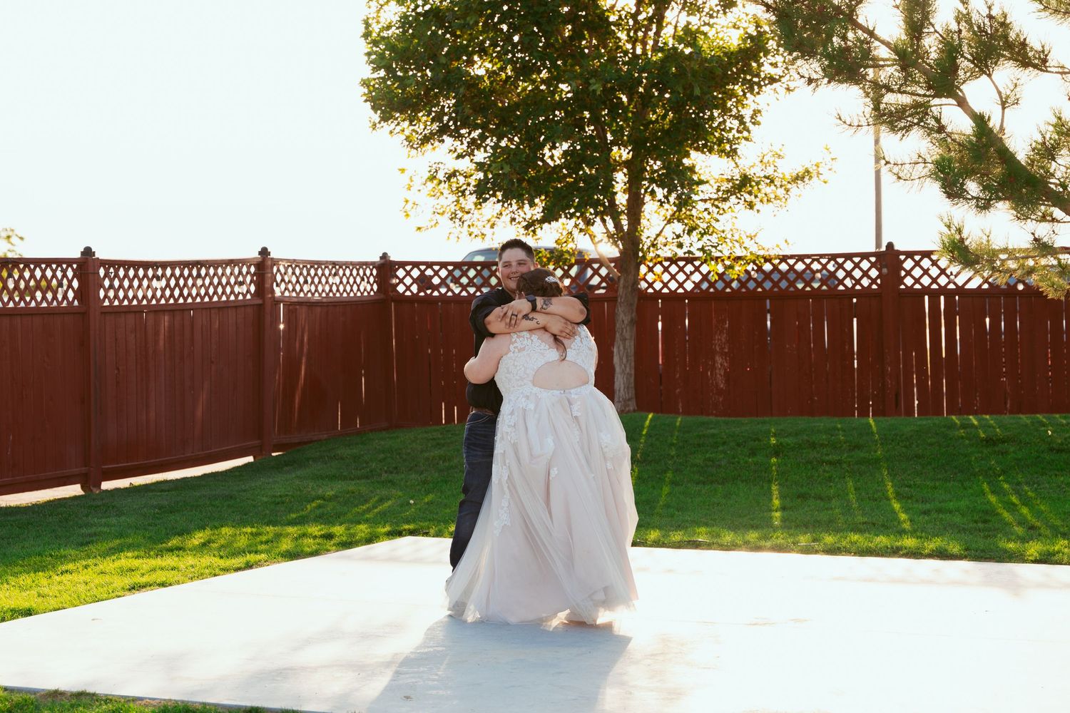 Outdoor wedding reception photos with wooden fence and greenery backdrop during golden hour.