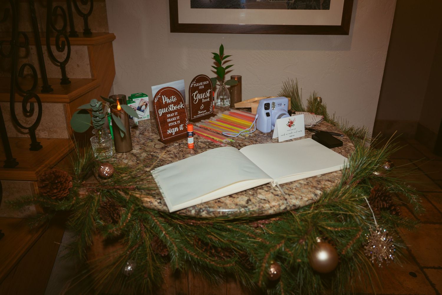 Holiday table setting with evergreen garland, gingerbread houses and festive decorations.