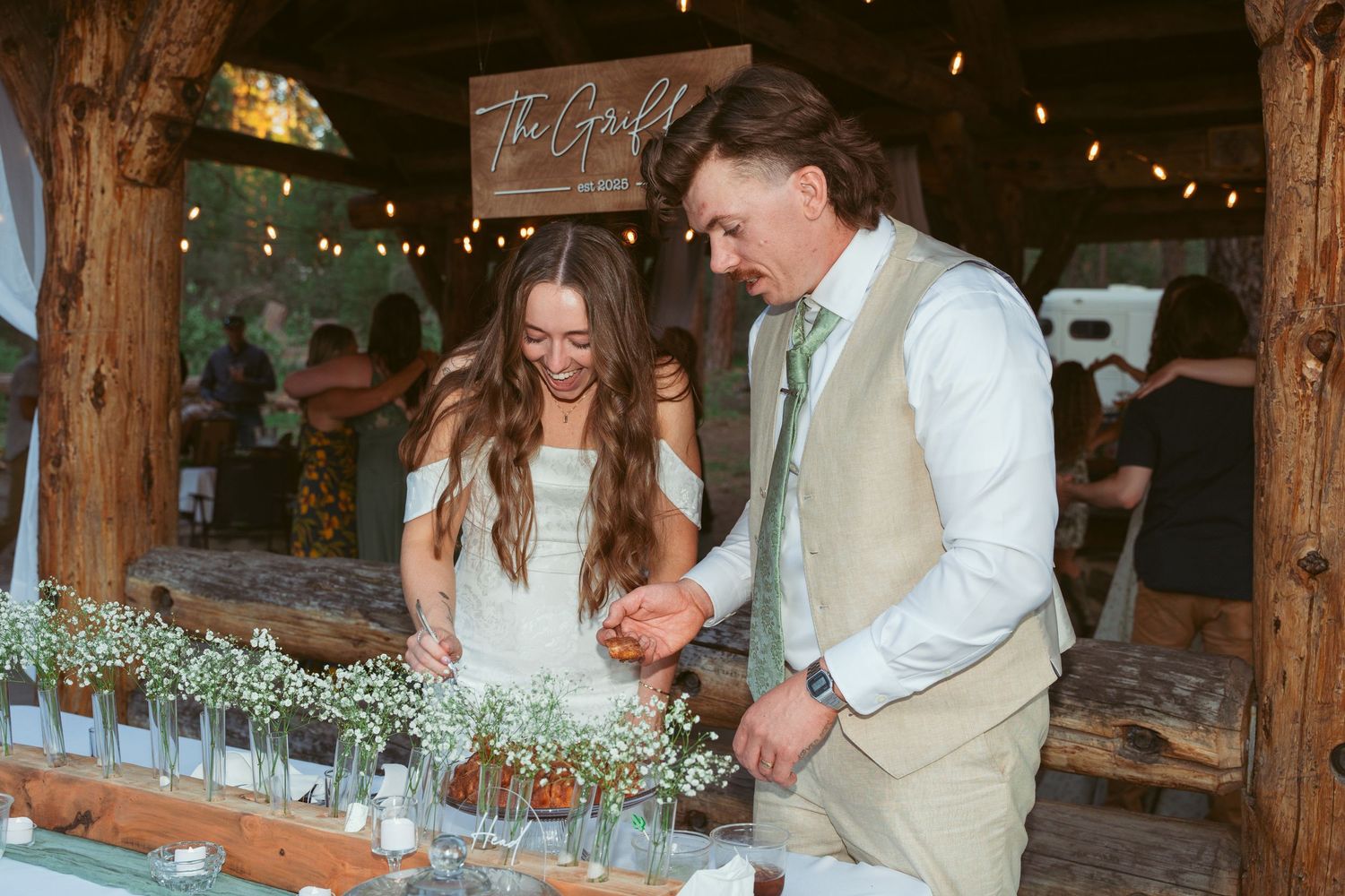 Elegant barn wedding reception featuring exposed wooden beams and romantic string light decorations.