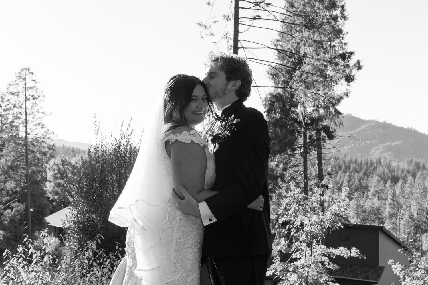 A romantic wedding ceremony moment captured in black and white on an outdoor deck.