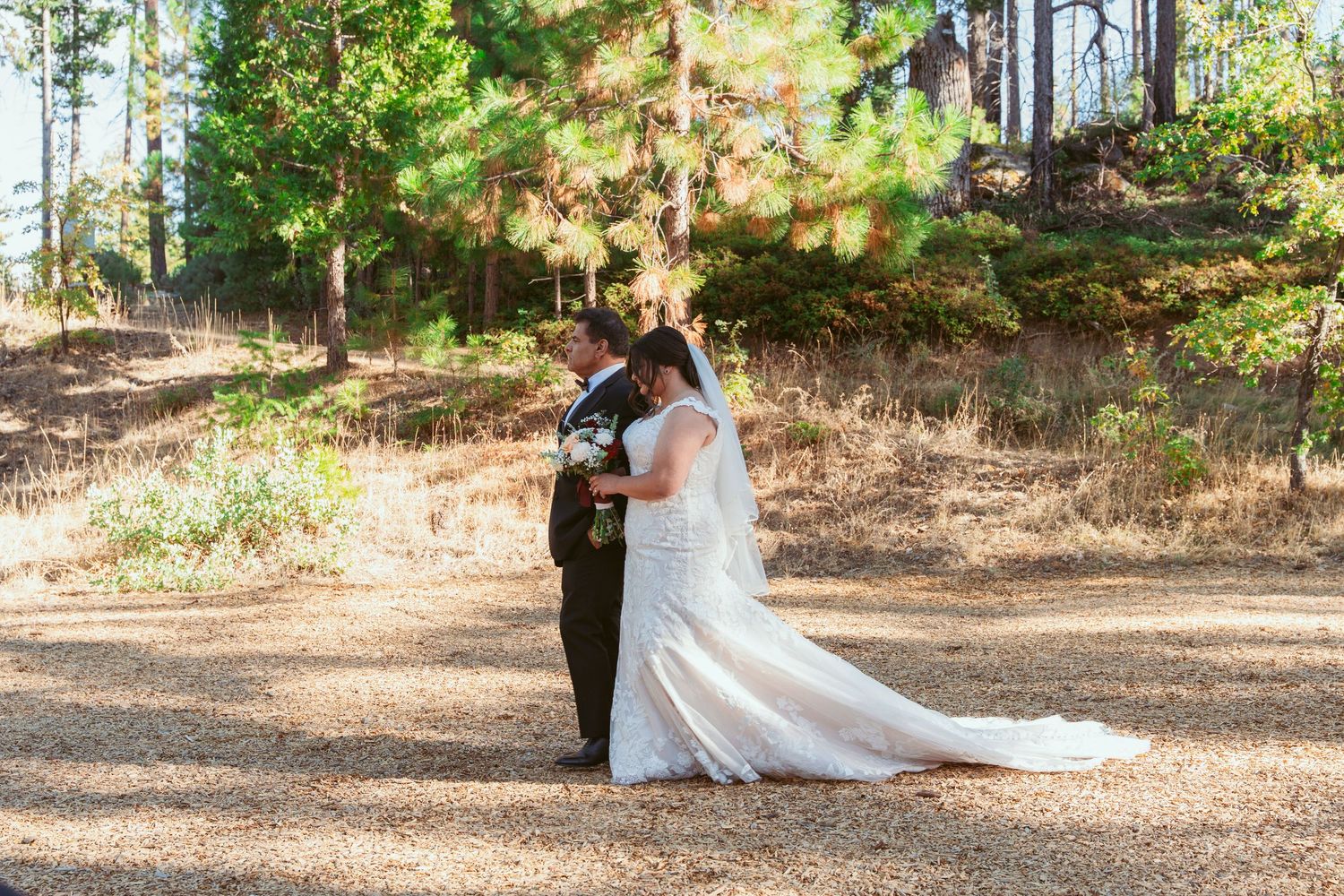 Couple shares intimate moment during forest wedding photoshoot.