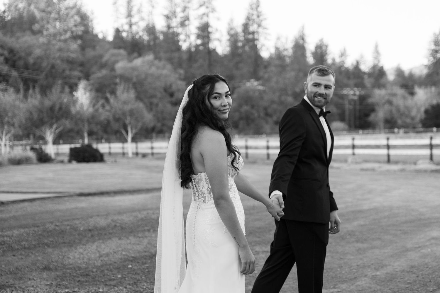 Romantic wedding portraits taken outdoors with mountain scenery and evergreen trees in the background.