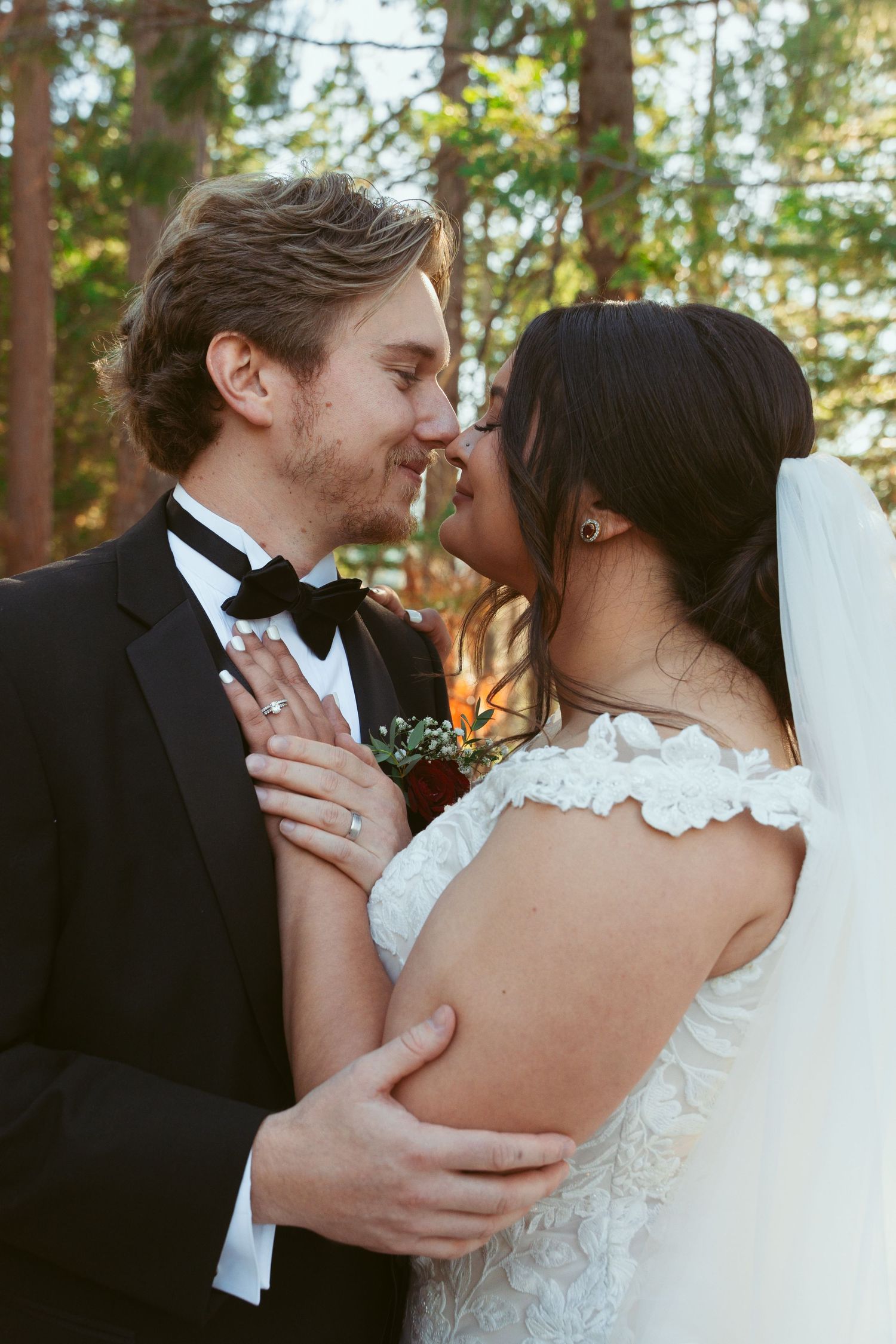 Romantic close-up of newlyweds sharing an intimate moment in a forest setting.