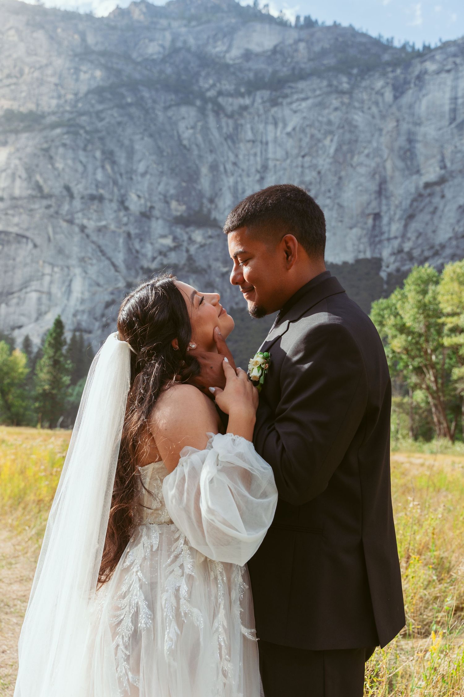 A romantic wedding photoshoot against dramatic mountain cliffs and meadows in Yosemite National Park.