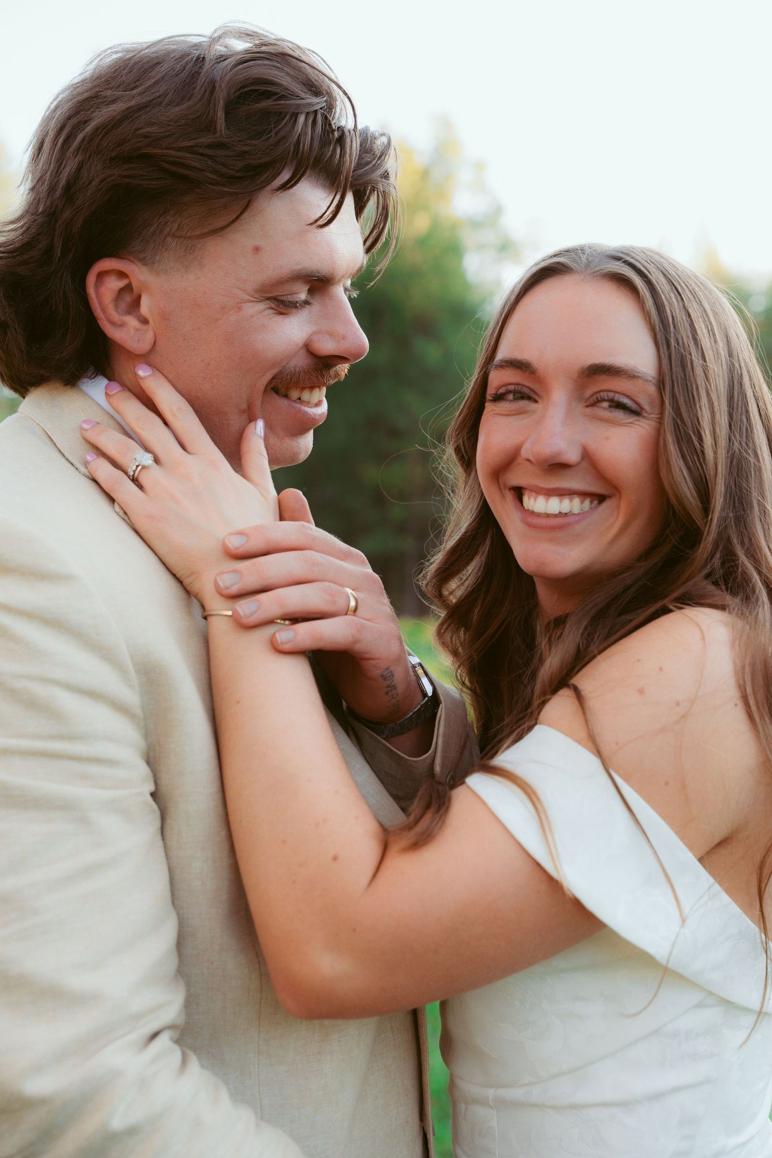 Candid close-up shots of a couple sharing joyful laughter during their wedding photoshoot.