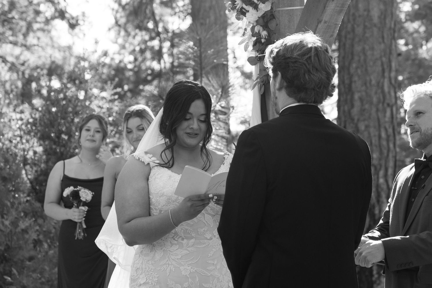 Black and white capture of wedding ceremony moments in forest setting.