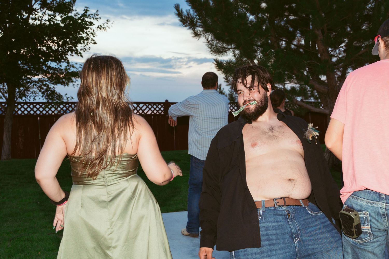 Group of guests gathered outdoors at sunset during a wedding celebration.