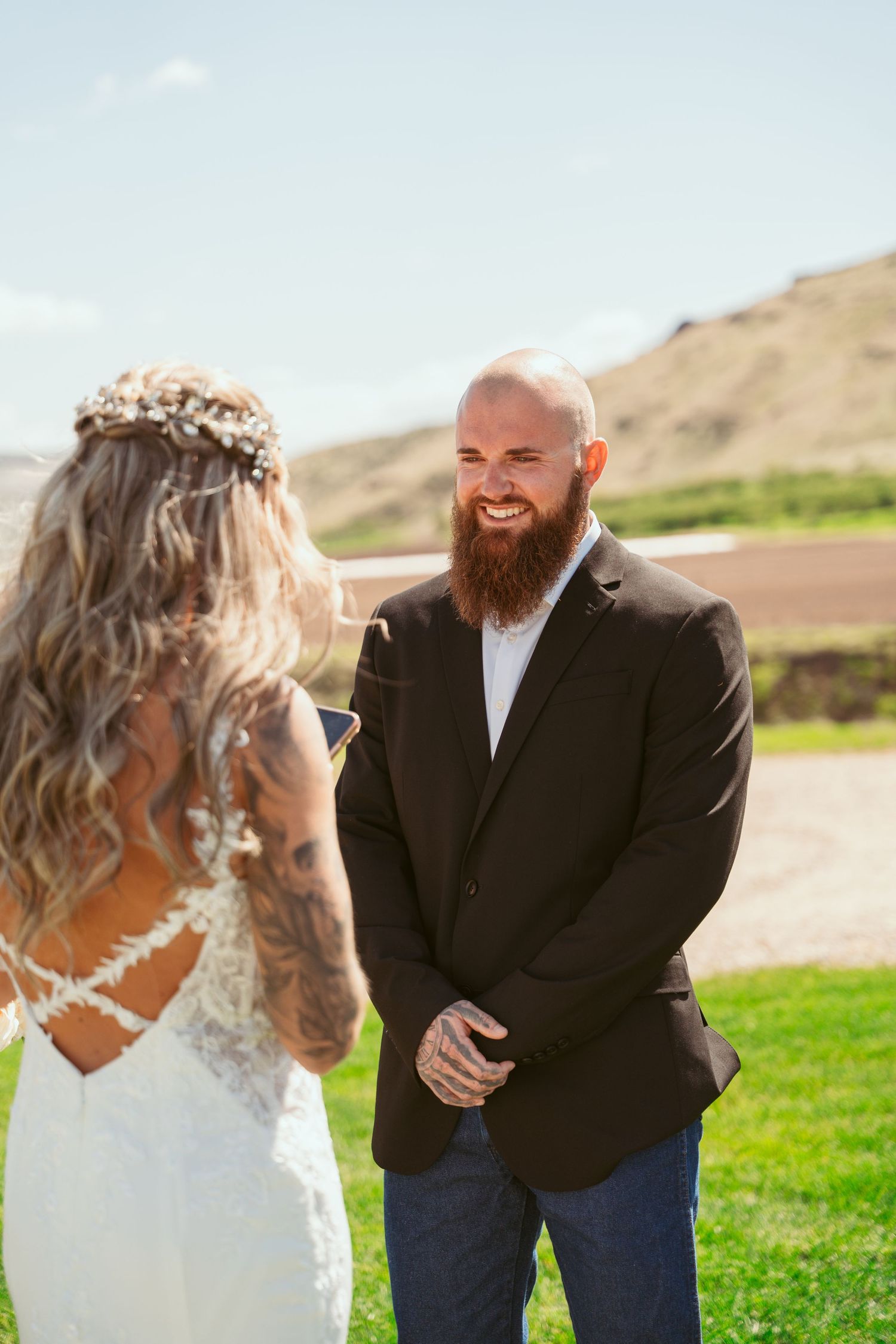 Outdoor wedding ceremony with mountain backdrop and natural scenery.