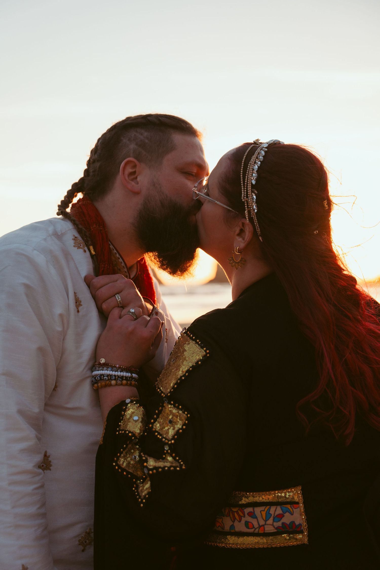 A romantic sunset silhouette of a couple in traditional dress sharing an intimate moment.