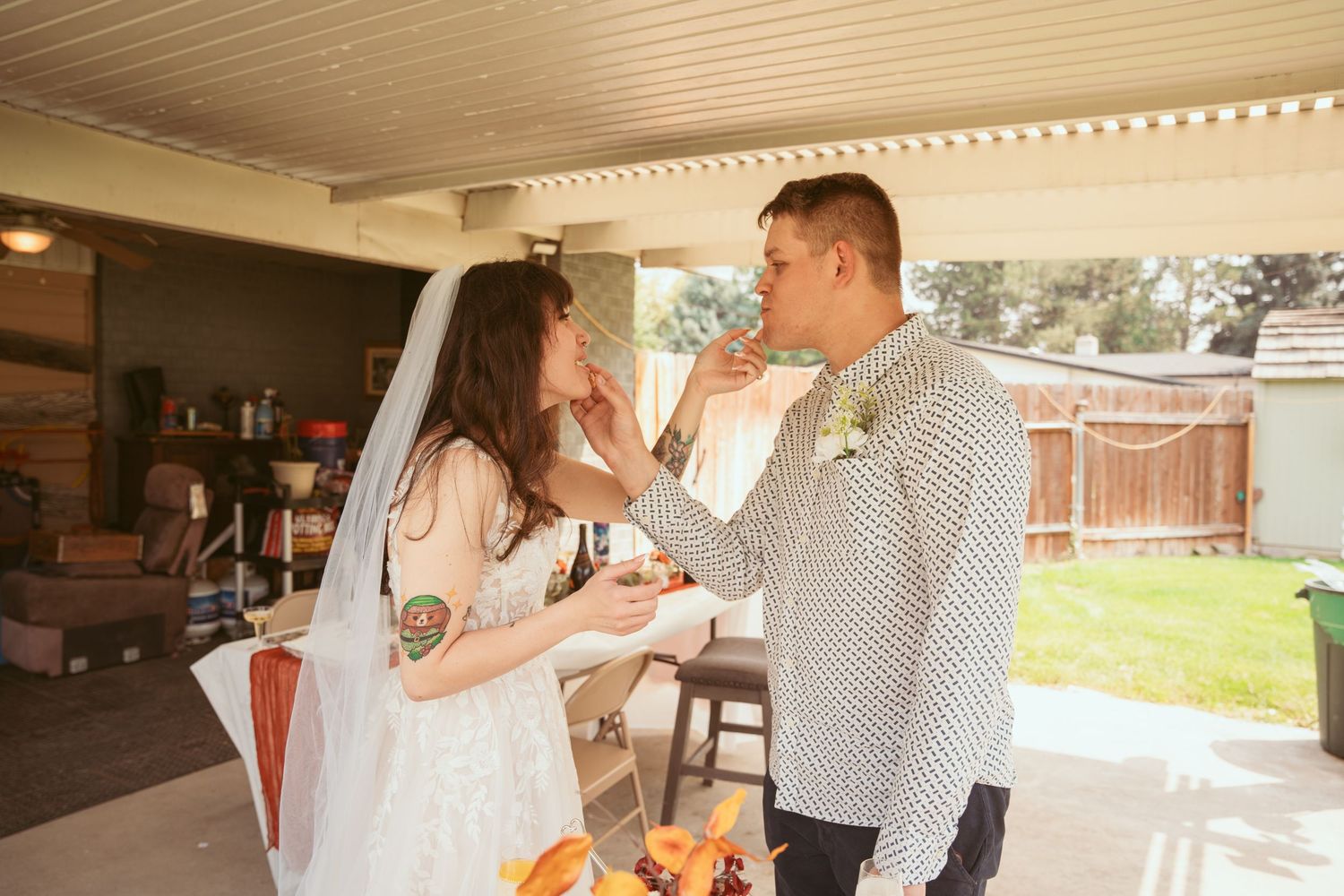 A playful wedding moment captured under a covered patio.
