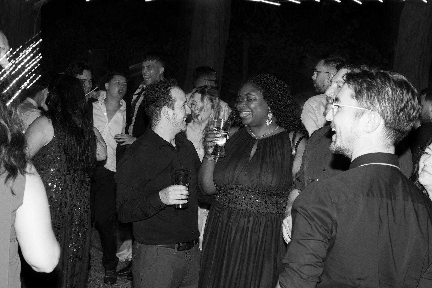 Wedding reception dance party with guests enjoying themselves on a dark dance floor.