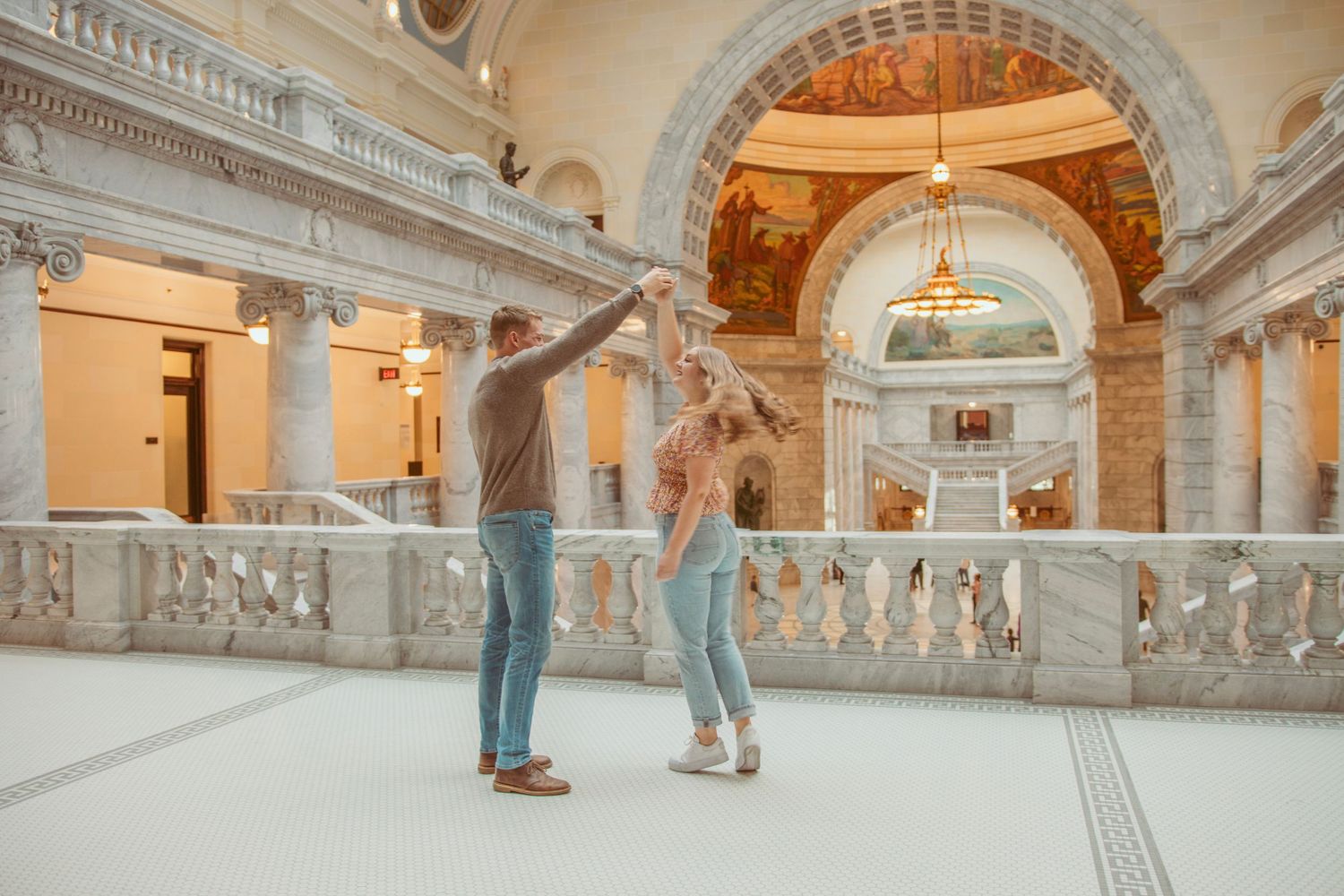 Grand marble hallway with classical columns and arched ceiling details.