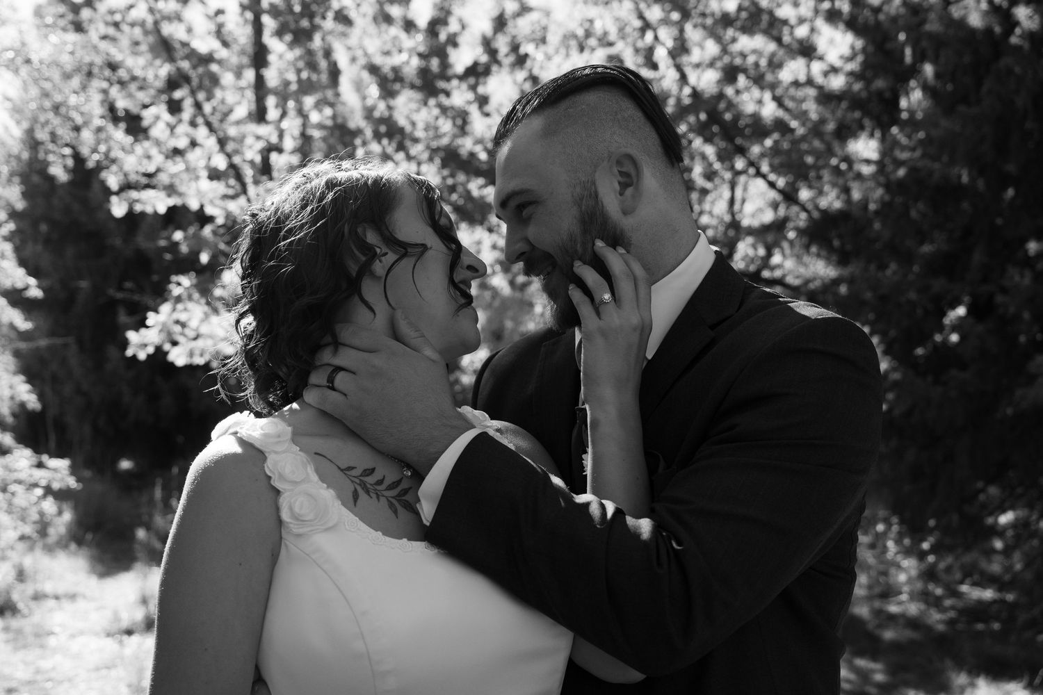 A black and white wedding photo showing a tender embrace between newlyweds.
