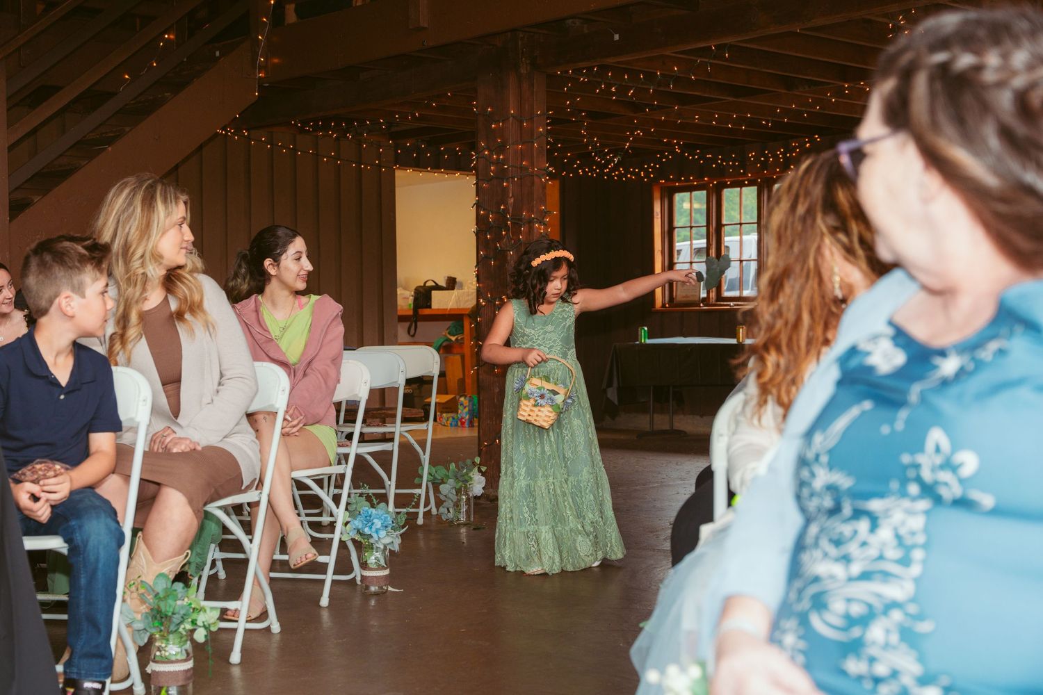 Wedding reception venue with string lights and wooden beams creating a warm atmosphere.